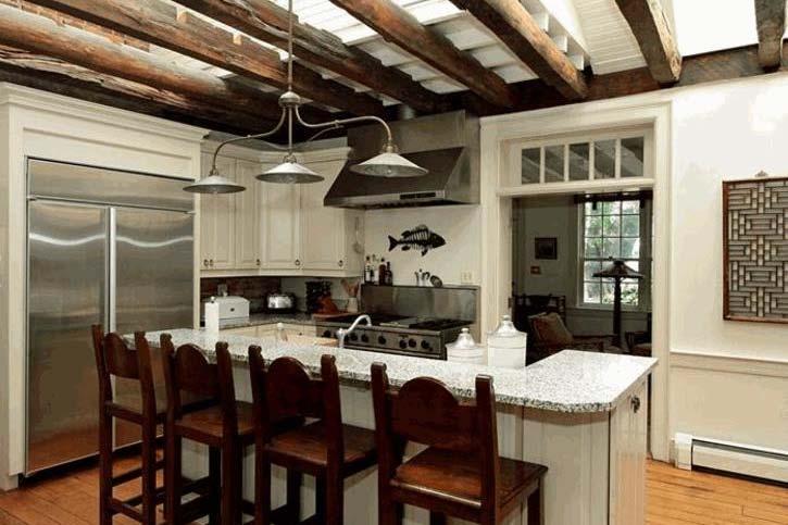 wood cabinets, chandelier over breakfast bar. Dutch door to side porch with slate tile floor and bead board ceiling.