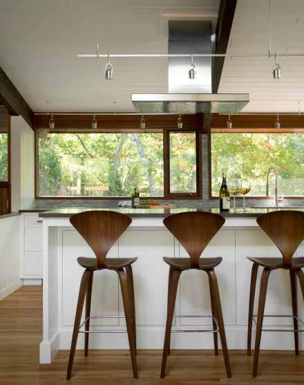 the kitchen s counter stools are a classic midcentury design by Norman Cherner. Crafted of molded plywood, the stools have an elegant silhouette against the white island.