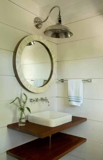 the powder room is small but functional. Faucets built into the wall serve the vessel sink, which is affixed to a mahogany base.