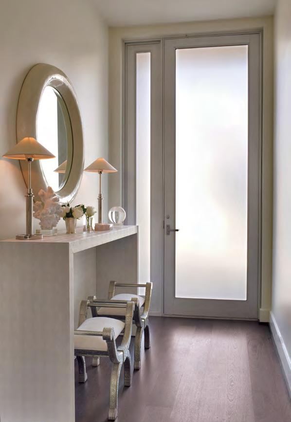 In the entry, designer Chandos Dodson Epley used white-on-white tones via a lacquered mirror from Baker above a custom console by The Joseph Company.
