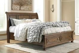 (Signature Design) Classic Porter design finished in a relaxed deep tobacco color Constructed with Acacia veneers and hardwood solids Storage footboard can be used with panel or sleigh headboards