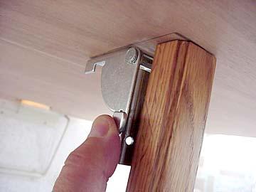 Release the table leg from the floor support bracket.