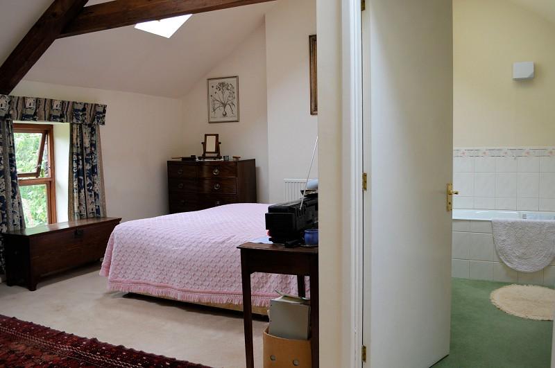 Bedroom 3 (16' 5" x 11' 0" Min) or (5.0m x 3.35m Min) Built-in wardrobe; Vaulted ceiling with exposed 'A' frame timbers; Three roof lights; Window to front; Radiator.