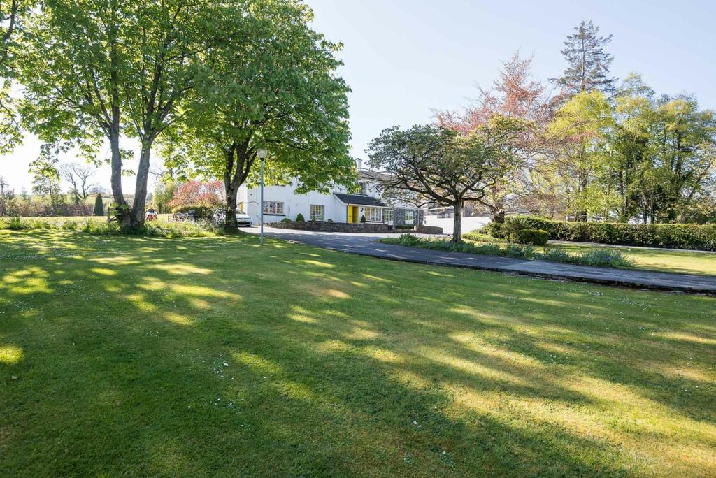 GARDENS Extensive landscaped mature gardens to front, side and rear, laid out in sweeping lawns, planted with a fine selection of evergreen and deciduous trees including Silver Birch, Beech,