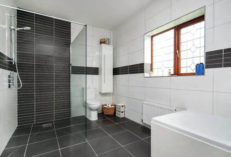 EN-SUITE SHOWER ROOM: Fully ceramic tiled to floor and walls, corner shower cubicle with jet system, concealed cistern w.