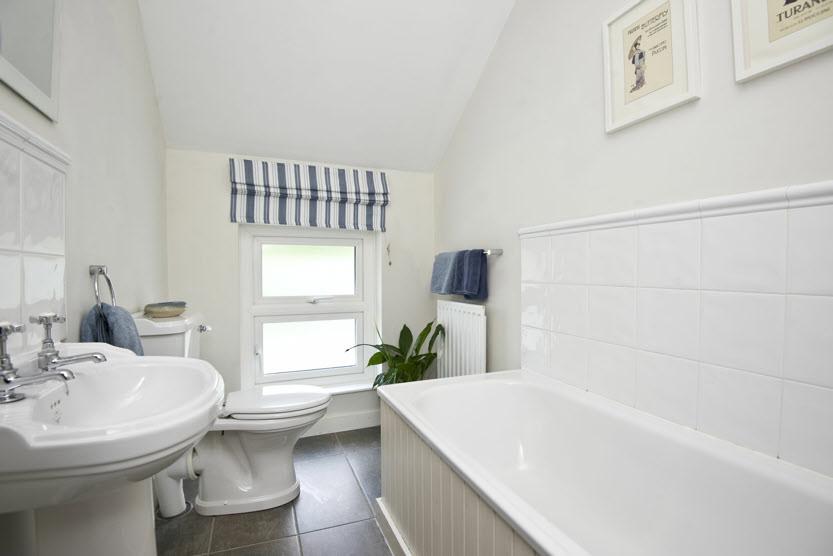 BATHROOM: White suite comprising panelled bath with telephone hand shower, double wash hand
