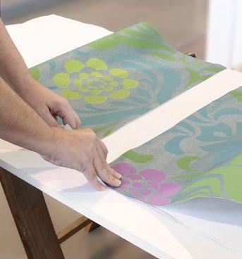 Fold the paper over on itself, lining up the edges as you go along, and then cut along the fold using a pair of scissors.