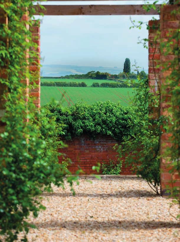 The walled garden is largely grassed and interspersed with raised beds, herbaceous