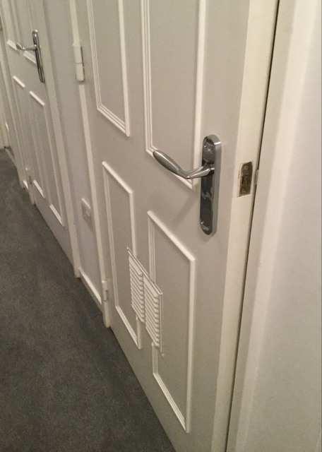 White painted door frame, continuation of the white smooth painted walls with MDF paneling to the top with screw showing, with a floor mounted Ideal E-type boiler, not tested, marks and