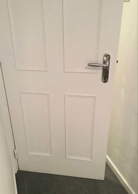 Chrome pull down lever handle with metal threshold, dragging to the floor to the carpet, interior side of the door the same, white painted door frame and white