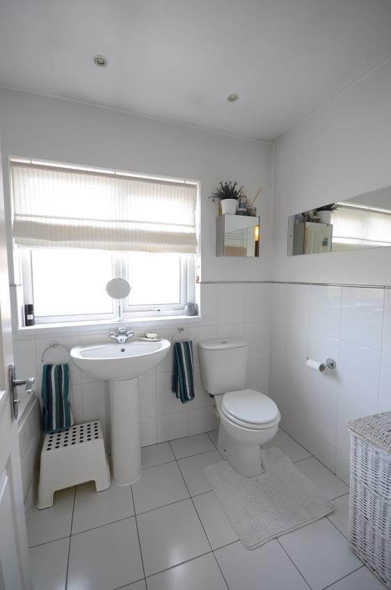 Deluxe Bathroom: 8/3 x 6/0 with part tiled walls and tiled floor, fashionable white suite comprising panelled bath with chrome taps and modern Mira electric shower unit