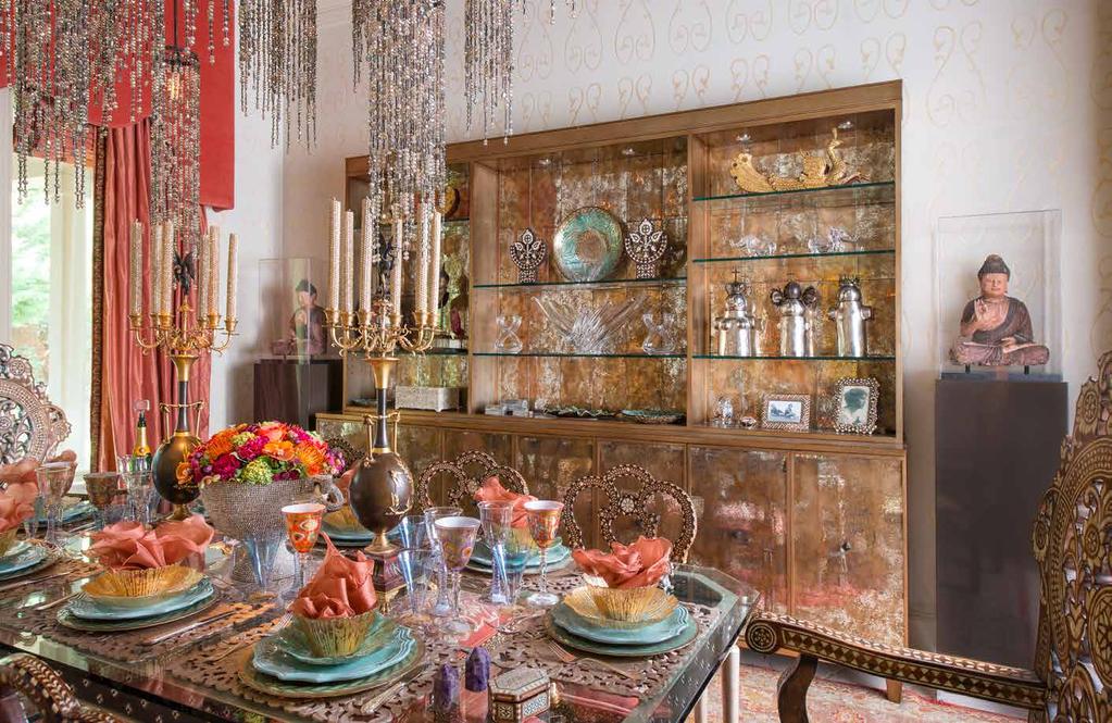 The dazzling chandelier is from Allan Knight and Associates, as are the custom dining table and pair of antique Buddhas. The dining chairs are from AOI Home.