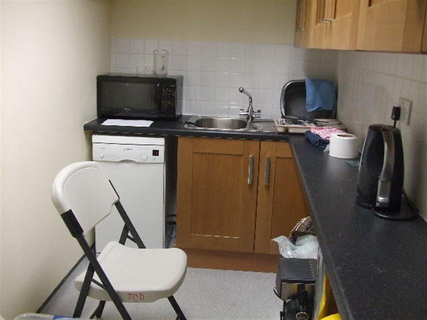 c Building 27 kitchen area: Microwave oven not mounted so that the base of