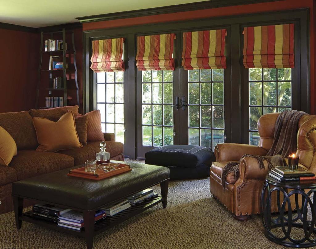 Rich chocolate trim frames the deep red walls of this cozy family room. Wall to wall carpeting is by Stark. woods, sisals, silk and leather with strong elements of artwork and color, said Gerardi.