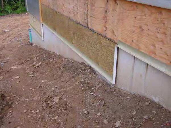 At the base of the wall the trim flashing and insect screen was being installed behind the foam to cover and protect the exposed edges of