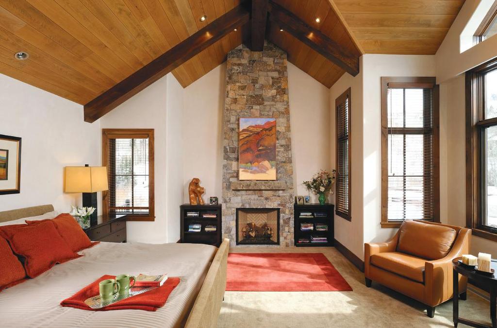 ABOVE: Red and orange jewel tones provide the rich accent hues of this master retreat. The fireplace mirrors the same stone, as well as identical wood beams from the great room.