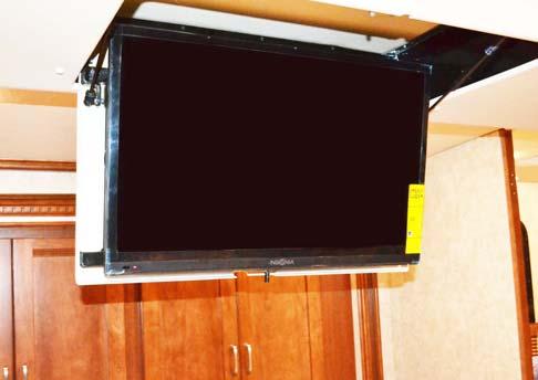 To Flip Down TV Place hand on TV housing and Push the release lever to lower TV.