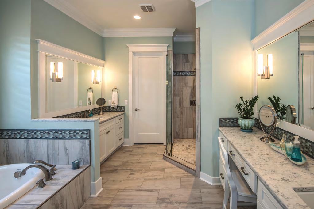 The master bathroom has intricate tile work and offers his and her vanities. finished kitchen establishes the range hood as the focal point. There are lots of drawers.