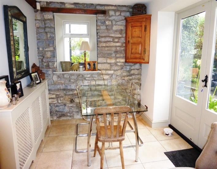 The dining area has an exposed stone wall at one end as well as a double glazed window and double glazed French doors to the rear garden. Tiled floor. Inset lights to the ceiling.