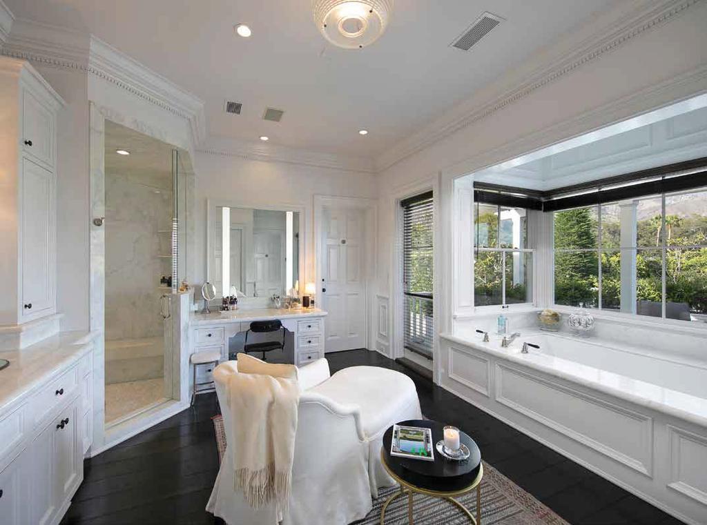 MASTER SUITE One of two baths in the master suite, this spa-like space is a vision in marble and white wood, featuring a spacious walk-in