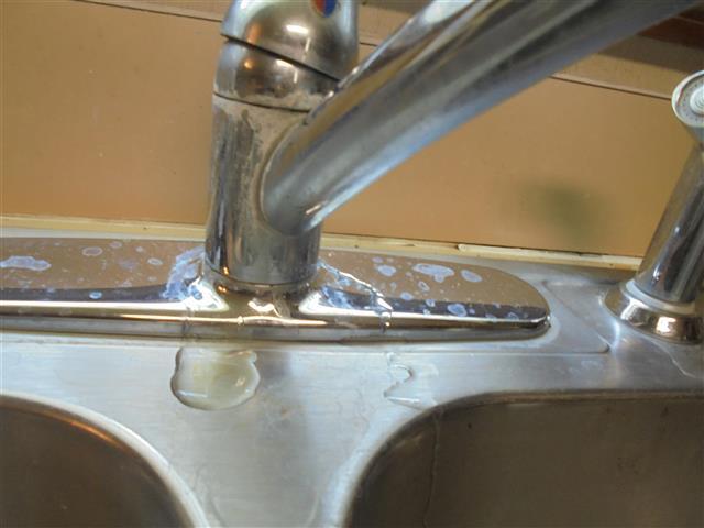 IV. PLUMBING SYSTEM ALL PLUMBING REPAIRS ARE ADVISED TO BE CORRECTED FROM A LICENSED PLUMBER / QUALIFIED PROFESSIONAL The kitchen sink faucet is leaking around its base.