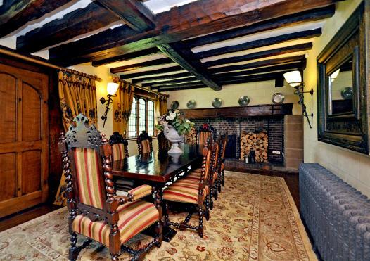 There is a FAMILY ROOM with an old brick fireplace with stone quoins and oak beam above, beamed and raftered ceiling, stone quoining to the walls and an open doorway into the BREAKFAST KITCHEN which