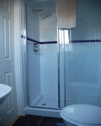 Tiled to full height at shower with tiled splashback at wash hand basin. Extractor fan. Central heating radiator. Downlighter. Glass shelf.