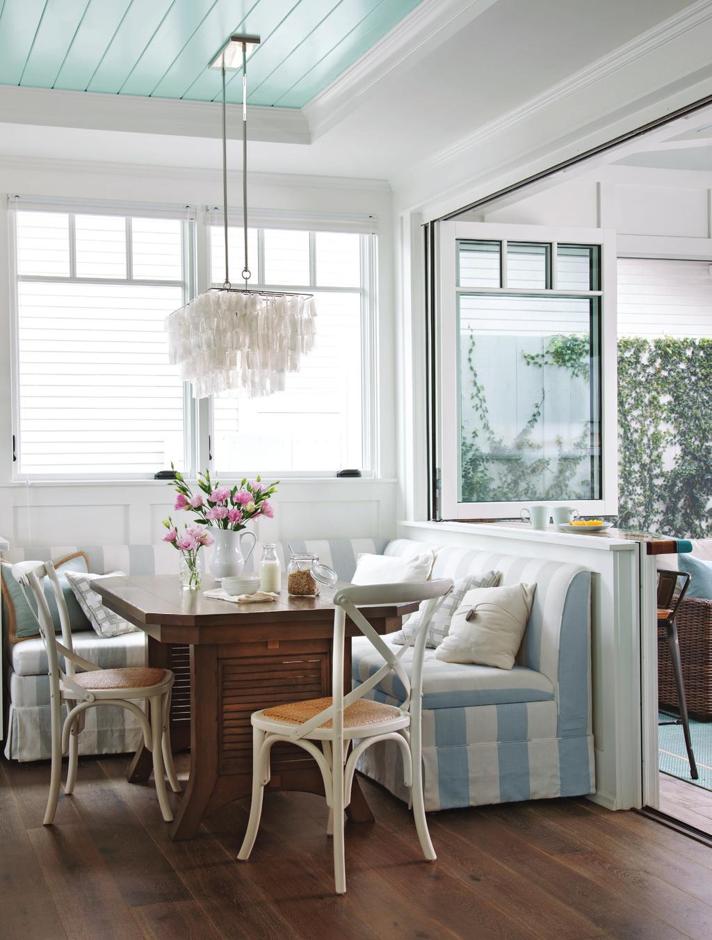 THIS PHOTO: A custom-made dining table tucks perfectly into the small banquette area.