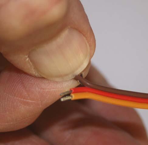 ensuring that the stripped section of the cable sits in the forward crimp as shown in the photograph.