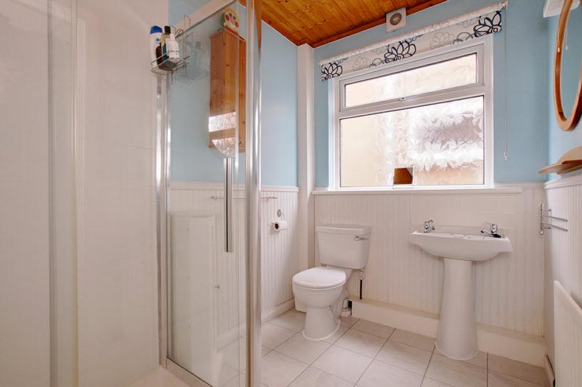 SHOWER ROOM: Fully tiled, double shower cubicle, Triton electric shower, low flush WC, pedestal