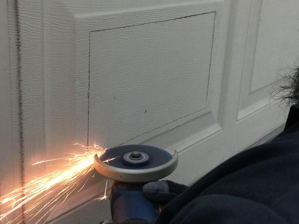Opening into Garage Door Use an angle grinder with