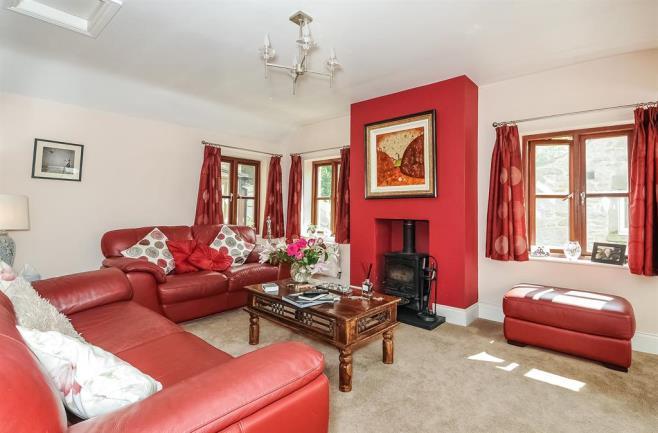 SITTING ROOM A striking living room of generous proportions and with superb long distance views over the village towards Giggleswick Chapel, from three large lowlevel Velux windows which open up to