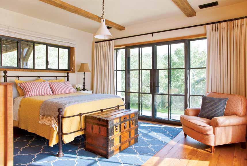 OPPOSITE: A light-filled guest room is furnished with family pieces such as an antique trunk and a custom flat-weave carpet by Matt Camron.