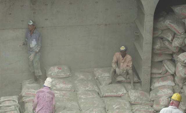 WORKERS UNLOADING CEMENT FROM