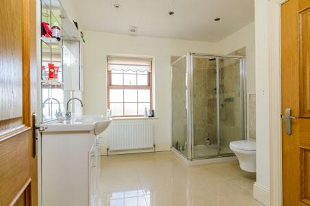 ENSUITE SHOWER ROOM: White suite comprising vanity unit with built-in mirror and