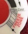 Remove the red portion of the Cold Tank Temperature label to access the adjustment screw.