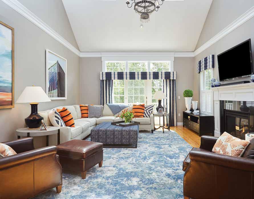 {designerstyle} In the great room, artwork and pillows bring bright color to an otherwise neutral palette. Custom draperies are an ivory-and-navy fabric from Osborne and Little.
