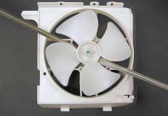 Note: In the following step, the fan blade is firmly attached to the D-shaped motor shaft. It may be helpful to use 2 flat blade screwdrivers, as shown, to remove the blade from the motor shaft. 7.