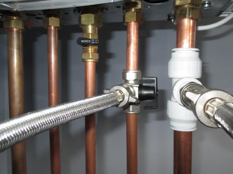 This is a photo of the underneath of a typical combi boiler before the gauge is fitted with the filling loop in place. The 15mm copper pipe 2 nd from the right is the cold water inlet.
