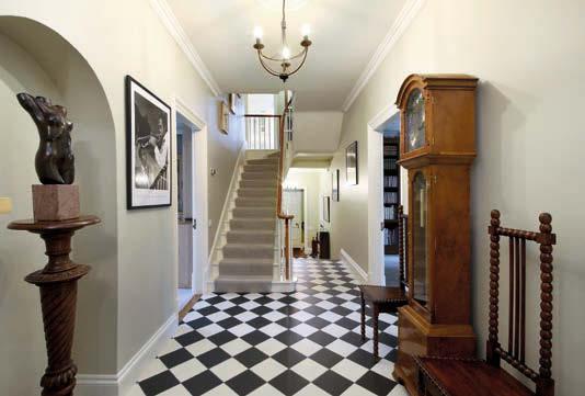 A solid wood front door leads into the long, spacious reception hall with black and white tiled floor, with library area to the rear and a door with inset stained glass leading to the orangery.