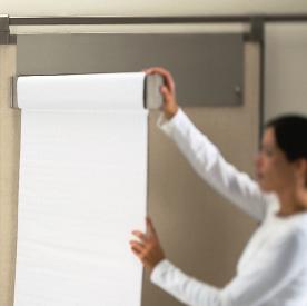 Flip chart holder connects to a wall board. Pivoting arm allows paper to flip easily. Get Set wall boards are designed for lightweight, lift-and-turn functionality.