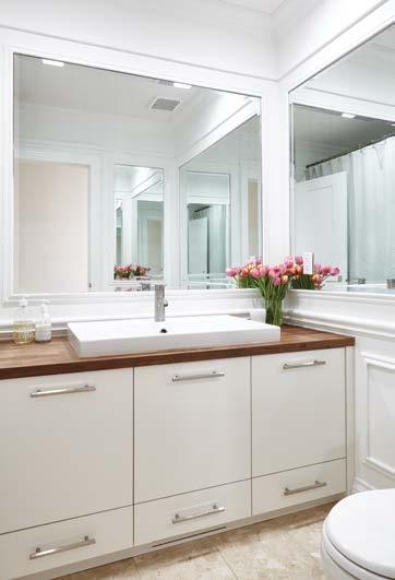 The main bathroom utilizes mirrors and millwork to reflect light.