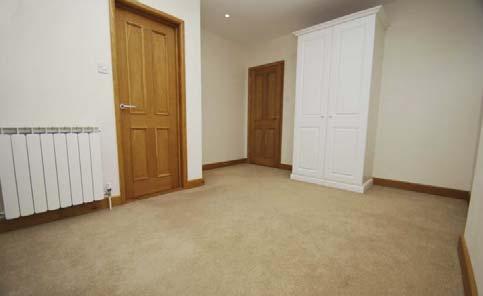White three piece suite comprising low level WC, wash hand basin and shower cubicle.