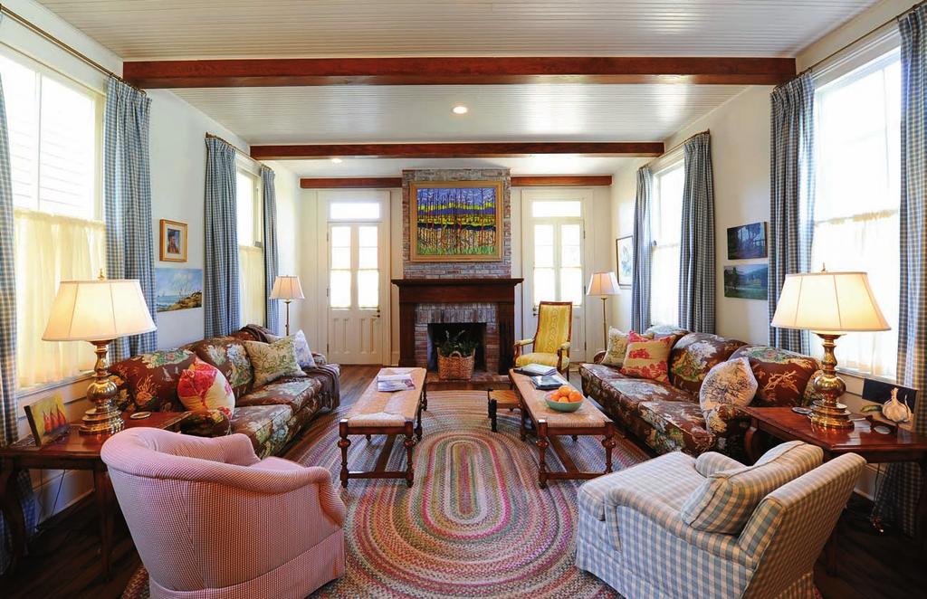 This page, top: A colorful hooked rug adds interest in the family room, which is furnished with a pair of large couches covered in a bold pattern fabric and wicker benches used as coffee tables.
