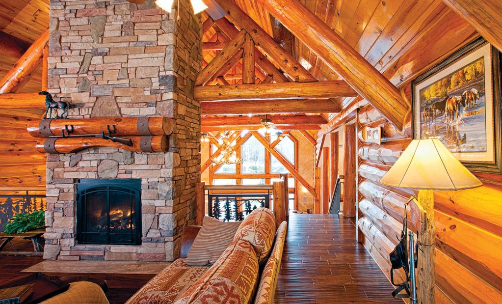 The loft sitting area, which separates the master bedroom from the three other bedrooms, celebrates the home s large logs and features an efficient