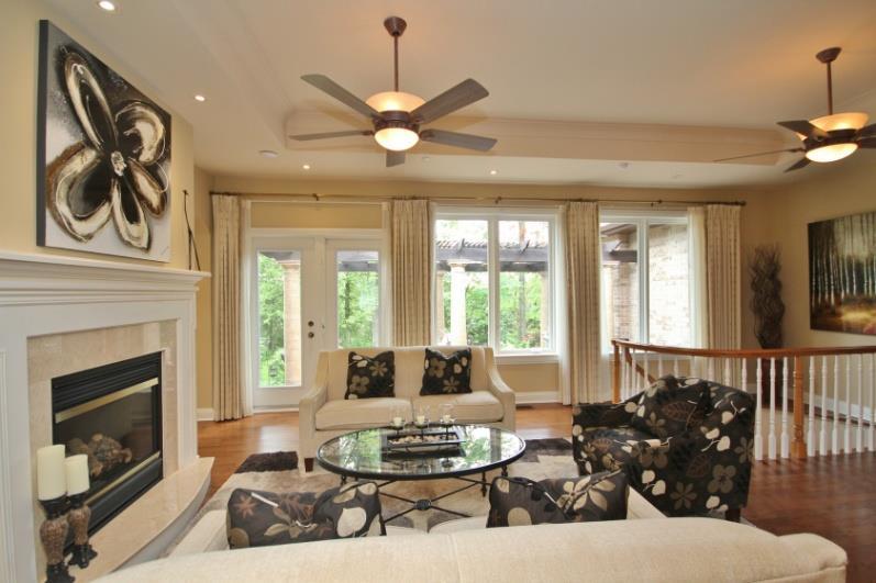 Living Room: offers a tray ceiling, pot lights, ceiling fan & beautiful gas fireplace with marble surround& wood