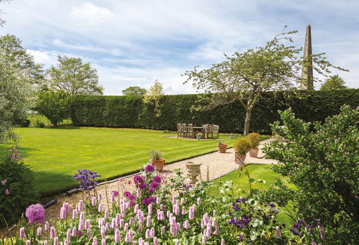 Gardens and grounds Welcombe Bank Farm is approached via a long driveway lined with fields to either side enclosed by post and rail fencing The driveway leads to
