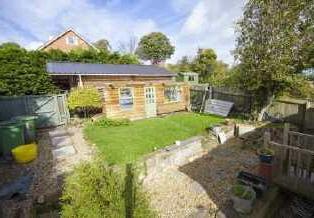 Side and Rear Garden A lovely enclosed private terraced garden with two patio areas, steps up to a lawned area,