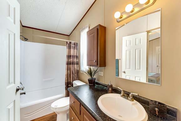 Adjacent to the bedroom is a private bathroom featuring a large countertop with integrated