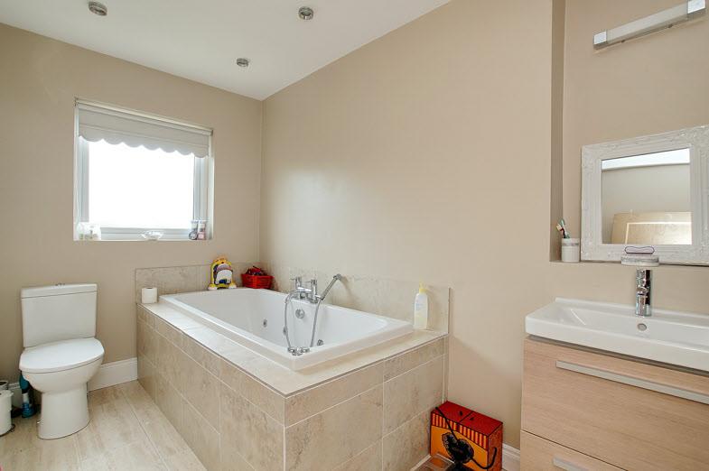 BATHROOM: Luxury white suite comprising tiled panelled Jacuzzi style